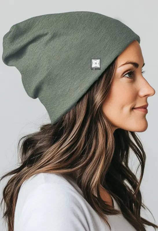Woman wearing a green beanie with a logo on a light gray background